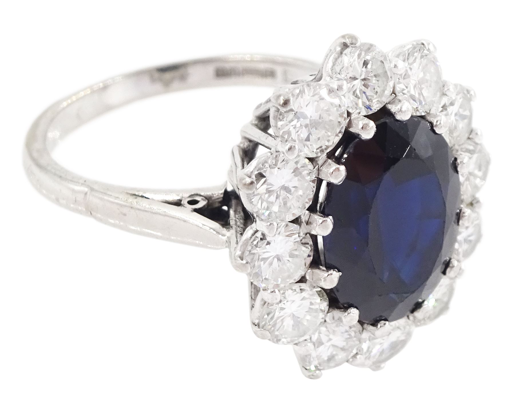 18ct white gold sapphire and diamond cluster ring, single oval cut sapphire of approx 4.50 carat, surrounded by twelve brilliant cut diamonds, Birmingham 1982, total diamond weight approx 2.65 carat