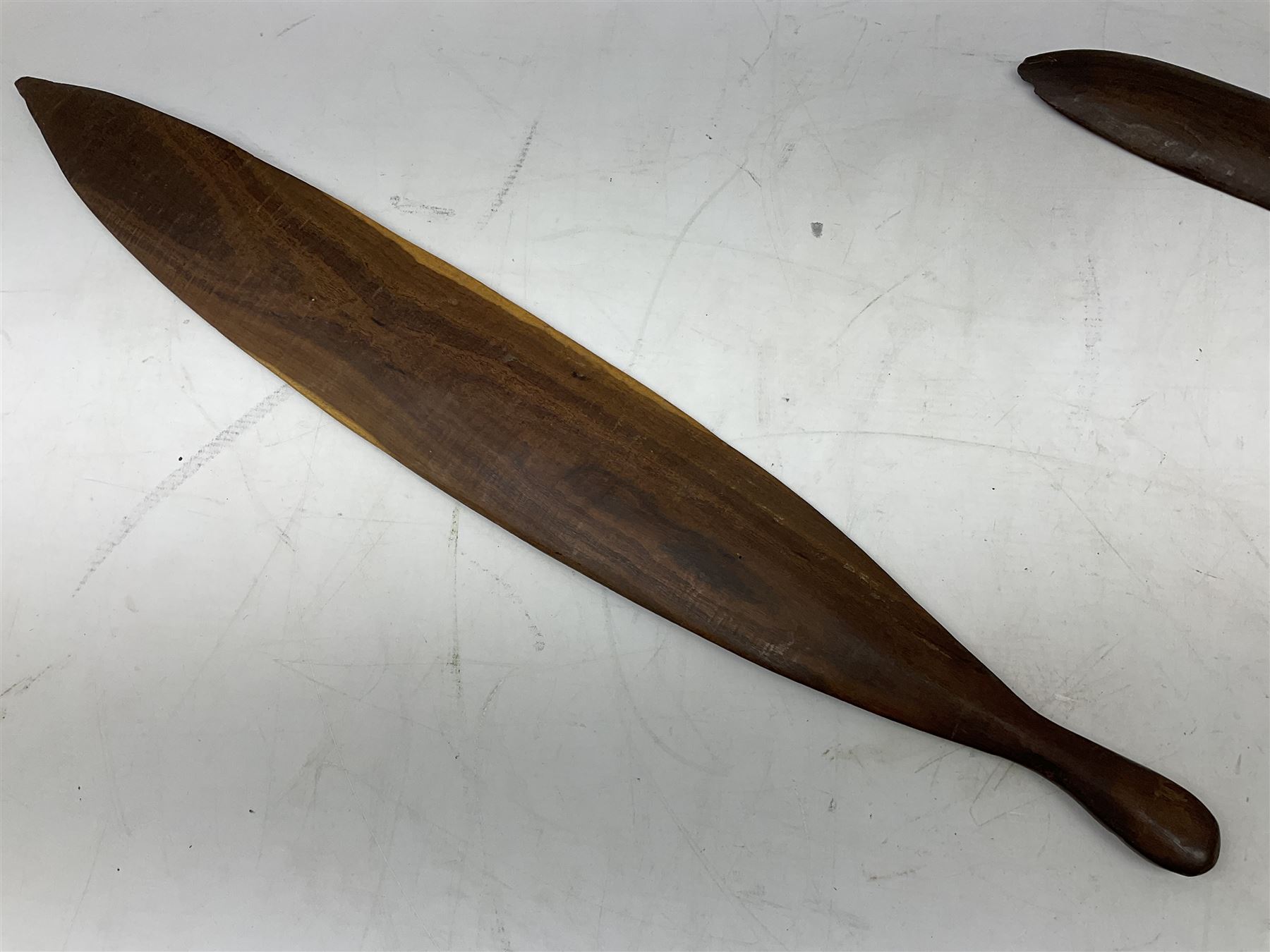 Australian aboriginal woomera spear thrower incised/carved with a wavy line and dots L69cm; and two boomerangs, one with carved geometric decoration (3)