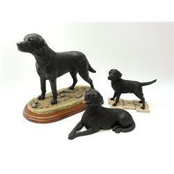 Two Border Fine Arts models, the first example a black Labrador, by Margaret Turner, upon oval wooden base, the second example a Dogs Galore Black Labrador, together with a Sherratt and Simpson model of a black Labrador