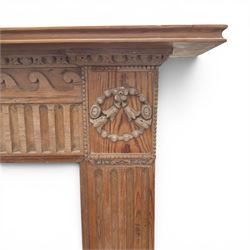 19th century Adams design pine fire surround, egg-and-dart carving over Vitruvian scrolls and fluted frieze, decorated with applied carved festoons and garlands, on fluted uprights
