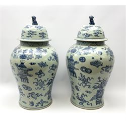 A large pair of 20th century Chinese blue and white vases and covers, of baluster form, the bodies decorated with various precious objects and auspicious symbols, the covers with Fo dog finials, H54.5cm. 