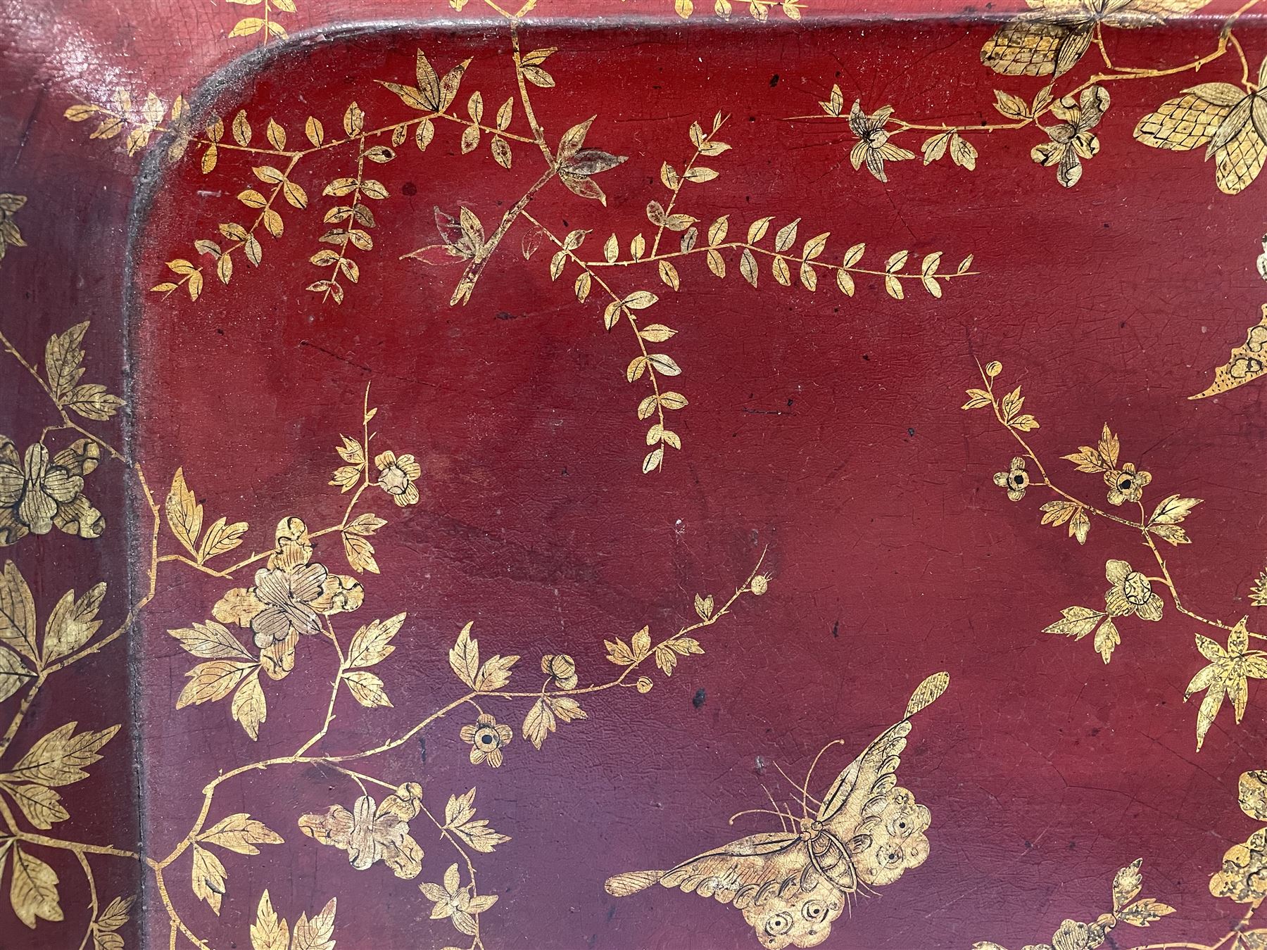 Early 19th century red lacquered papier-mâché tray by Clay of King Street Covent Garden, of rounded rectangular form, painted in gilt with large foliate sprays and butterflies, impressed verso CLAY KING ST COVENT GARDEN, W66.5cm D48.5cm