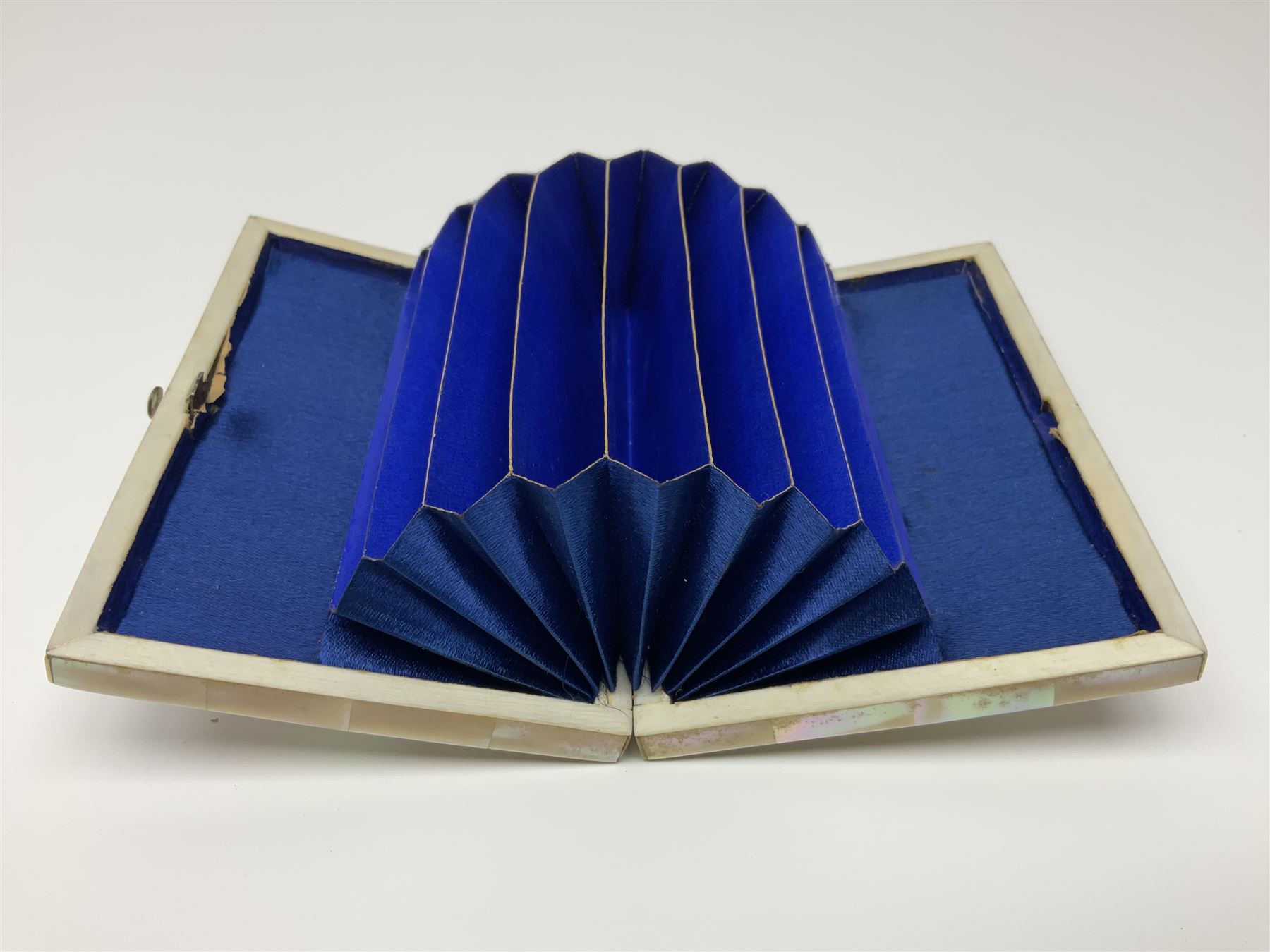 Victorian mother of pearl tea caddy, of rectangular bow-fronted form, the body with floral, bird and geometric engraved mother of pearl panels, white metal shield plaque to the cover inscribed with the initials G.J.A and similar escutcheon, the two division interior with ivory edging and two panelled mother of pearl lids, on four vegetable ivory bun feet L20cm, together with a similar style mother of pearl card case (2) This item has been registered for sale under Section 10 of the APHA Ivory Act