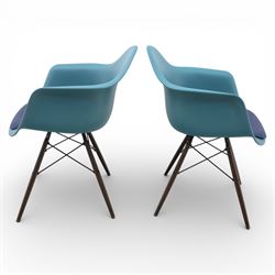 Vitra - Pair of Eames DAW armchairs, moulded plastic seats in teal with integrated armrests, blue upholstered seat cushions, supported on stained wooden dowel legs with black wire cross bracing