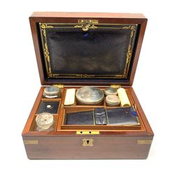 A 19th century mahogany brass bound vanity box, the hinged cover with vacant brass cartouche opening to reveal a fitted interior, with bone handled brushes and glass jars with silver plated covers, L27.5cm D20cm H12.5cm. 