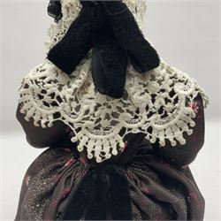 Anna Meszaros Hungary - hand made needlework figurine 'Old Lady' seated on a stool wearing a lace trimmed black/white/red floral full length dress and hat, working on a piece of lace H30cm  Auctioneer's Note: Anna Meszaros came to England from her native Hungary in 1959 to marry an English businessman she met while demonstrating her art at the 1958 Brussels Exhibition. Shortly before she left for England she was awarded the title of Folk Artist Master by the Hungarian Government. Anna was a gifted painter of mainly portraits and sculptress before starting to make her figurines which are completely hand made and unique, each with a character and expression of its own. The hands, feet and face are sculptured by layering the material and pulling the features into place with needle and thread. She died in Hull in 1998.