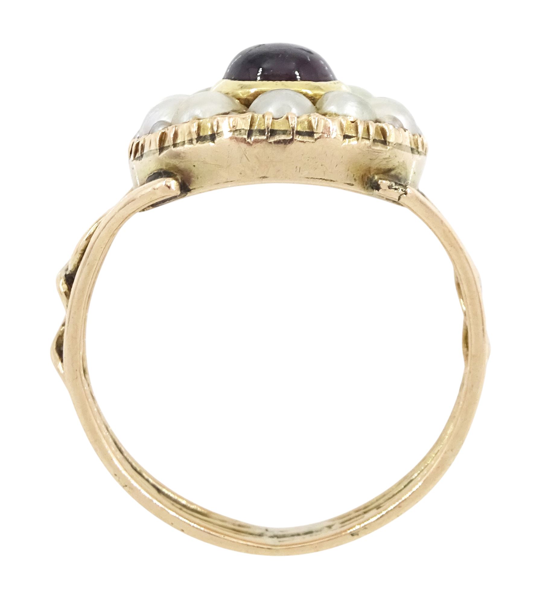 George III 9ct rose gold garnet and pearl mourning ring, single cabochon garnet, with split and seed pearl surround and pierced design shoulders, the back inscribed and dated 1808