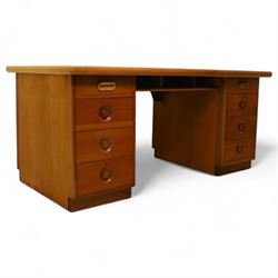 Mid 20th century teak twin pedestal partners desk, rectangular top with rounded corners with integral frieze storage shelf, above  pedestals each fitted with three drawers, recessed circular pull handles, cupboard doors fitted to the opposing side on concealed plinth bases