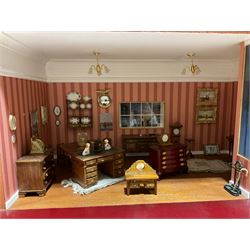 Good quality late 20th century dolls house by M. James dated 1995 in the form of a Beverley East Yorkshire Antique Shop called 'North Bar Antiques'; single-storey single-roomed shop with textured brick walls and flat roof, fully glazed hinged front with recessed hinged customer door and central window to the rear; comprehensively furnished with chests of drawers, pedestal desk, breakfast table, lowboy, two longcase clocks, delft rack with ceramics, occasional tables, pictures, Regency style mirror and collectibles; decorated walls with coving and picture rail and simulated floorboarding; wired for electric lighting; maker's plaque W61cm H42.5cm D41.5cm