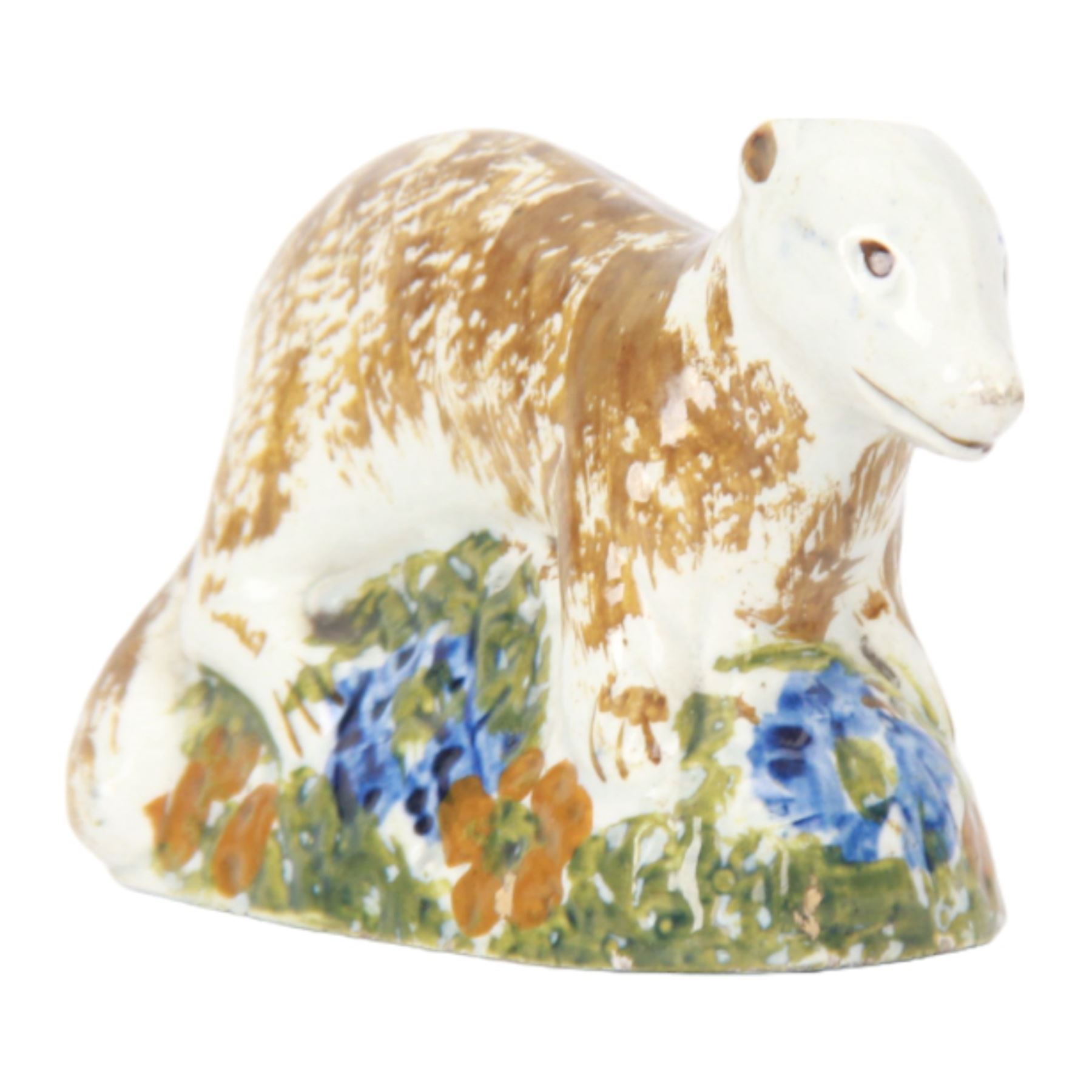 Late 18th/early 19th century Staffordshire model of a fox, the stalking fox decorated in Pratt type colours upon a green grassy mound base detailed with blue and ochre flowers, bearing Jonathan Horne labels beneath, H5.5cm L9cm

