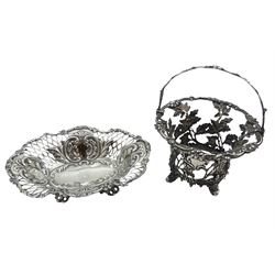 Late Victorian silver bonbon dish, of shaped oval form with scrolling foliate rim, pierced and repoussé decorated sides, and engraved monogram to centre, upon four shaped feet, hallmarked William Hutton & Sons Ltd, London 1896, L18cm, together with a Victorian silver openwork basket, of cylindrical form with flared rim and swing handle, upon four splayed feet, the sides naturalistically modelled in the form of oak leaves and acorns, hallmarked George John Richards, London 1849, excluding handle H8.5cm, approximate total weight 12.05 ozt (375 grams)