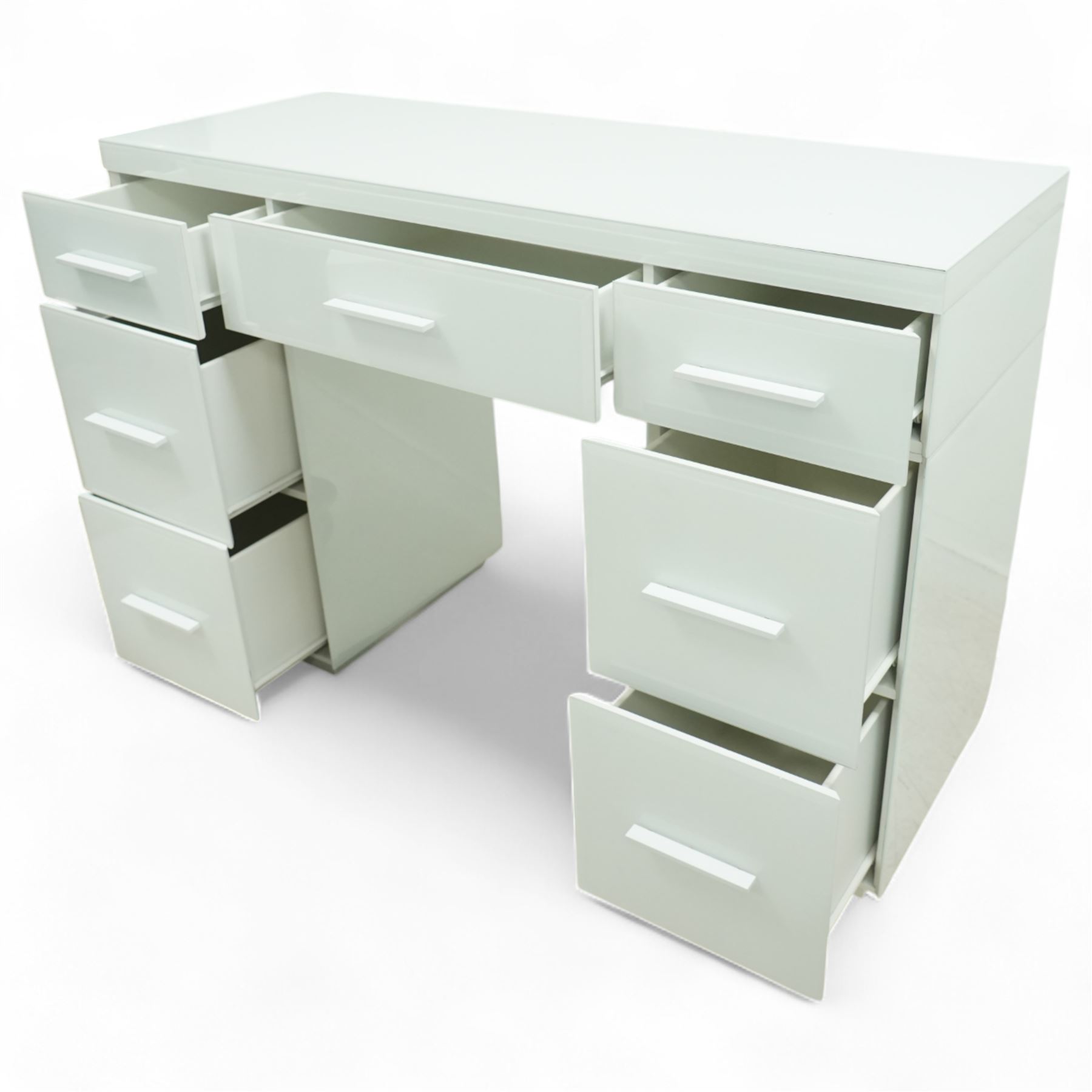 Contemporary white and glass twin pedestal dressing table and two matching bedside chests, dressing table with rectangular top above seven flush-front drawers arranged around a central kneehole, with white matching pulls, bedside chests each with square top over three drawers with integrated handles, plain sides and plinth bases

Bedside tables (W 121cm D 41cm H 82cm)
Dressing table (W 45cm D 45cm H 66cm)