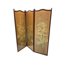 Early 20th century mahogany framed three panel screen, each glazed panel enclosing floral embroidery