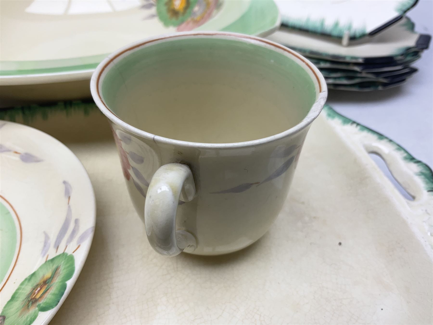 Clarice Cliff for Newport Pottery Corolla pattern tea and dinner wares, comprising triangular bowl, four side plates, two shallow bowls and teacup (a/f), together with a Clarice Cliff Wilkinson twin handled soup bowl and unassociated saucer both decorated with pink and yellow flowers, together with other mid century ceramics comprising Parrott and Company Coronet Ware, and Royal Staffordshire AJ. Wilkinson Ltd dinner wares
