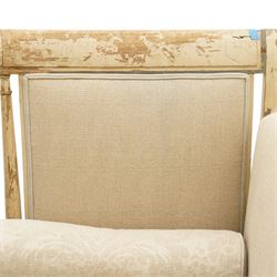 19th century French painted day bed, asymmetrical scrolled ends flanking a serpentine upholstered back, with upholstered end panels, loose seat cushions and cylindrical bolsters upholstered in beige fabric, with turned uprights with fluted detailing, moulded seat rail and lozenge-moulded corner blocks, raised on turned tapering supports