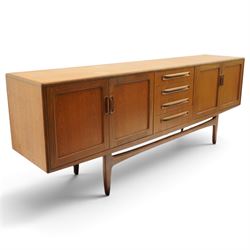 G-Plan - 'Fresco Long John' teak mid 20th century sideboard, a central bank of four drawers, flanked by twin cupboard doors, with recessed handles, on a tapering supports 