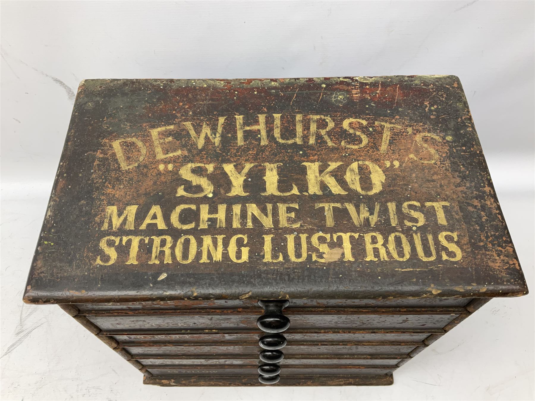 Early 20th Century Dewhurst table top chest, decorated with gilded 'Dewhurst's Sylko Machine Twist Strong Lustrous' lettering above six long drawers with names and numbers of cotton also detailed in gilt, H39cm