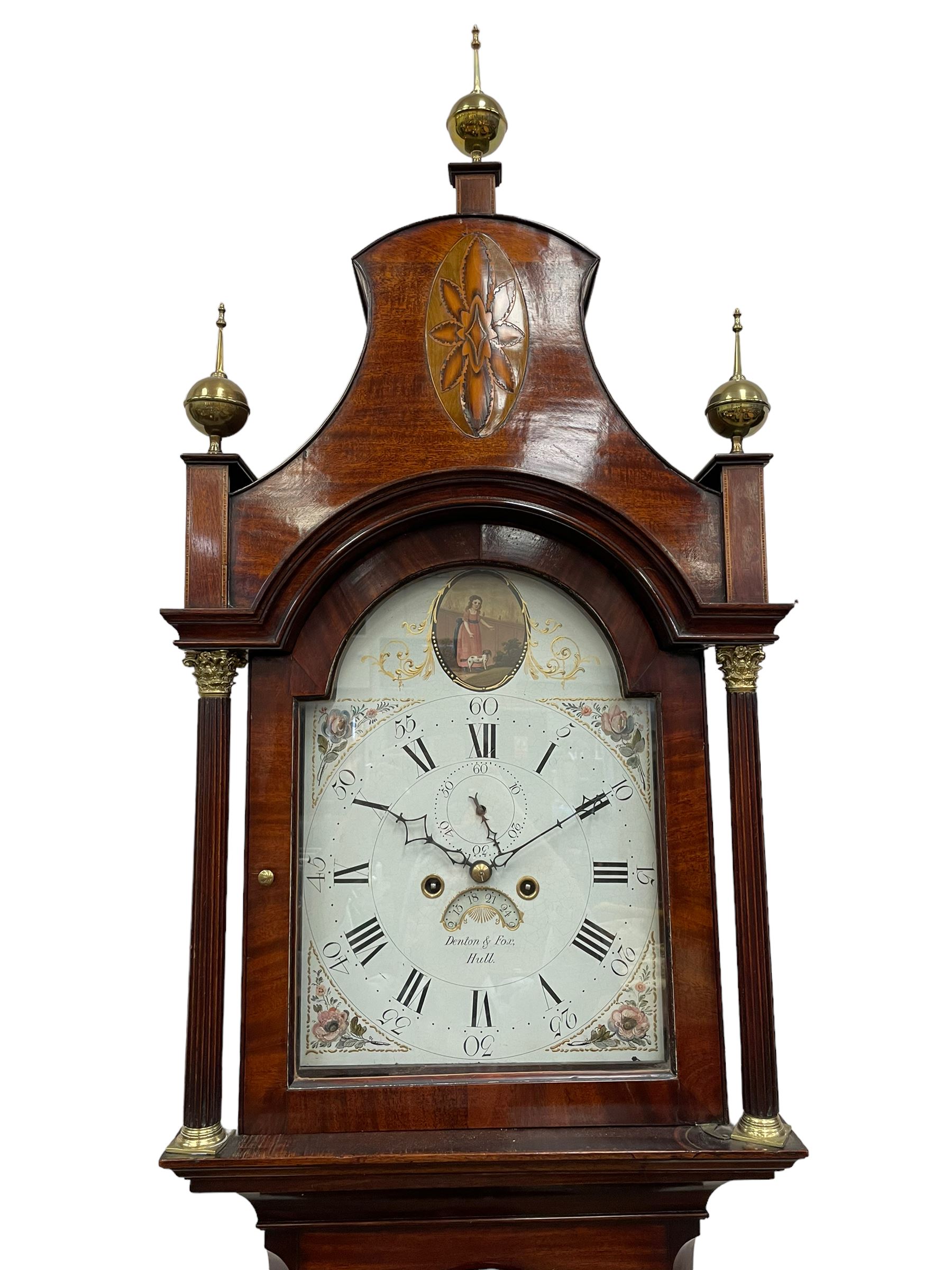 Denton & Fox of Hull – Early 19th century mahogany 8-day longcase clock c1802, pagoda pediment with an oval inlay and three ball and spire finials, break arch painted dial and hood door flanked by reeded pilasters with brass Corinthian capitals, long trunk door with conforming break arch top on a rectangular plinth raised on bracket feet, early Wilson (Birmingham) dial with Roman numerals, five minute Arabic’s and minute dots, subsidiary seconds dial and calendar aperture, with matching steel hands, floral spandrels within raised gesso work and a conforming oval depiction of a young maiden and dog to the break arch, dial pinned via a falseplate to a rack striking movement with a recoil anchor escapement striking the hours on a cast bell. With pendulum and weights.
Joseph Denton was a respected and prolific Hull clock maker working in Scale Lane Hull 1779 and Silver Street 1782-1814. Entering a short-lived partnership with Charles Fox from Beverley in 1802.
