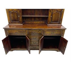 Traditional oak dresser, the moulded cornice over shaped apron, three heights plate rack fitted with two cupboards, the base fitted with six drawers and two double cupboards, panelled pointed ogee arched doors, on bracket feet