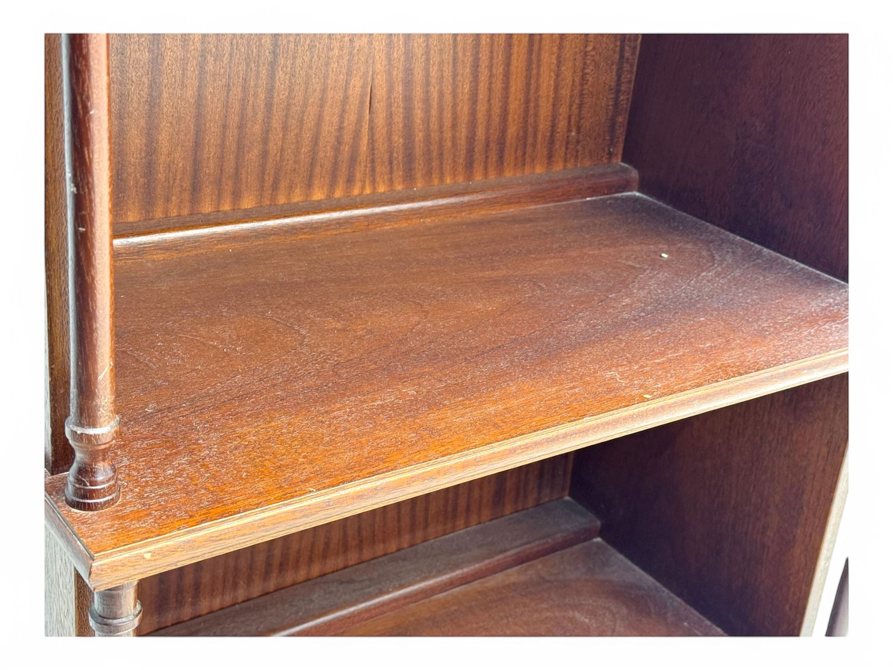 Mid-20th century mahogany open bookshelf, the rectangular top with a brass balustrade gallery, over three shelves each supported by turned column uprights, on shaped apron base