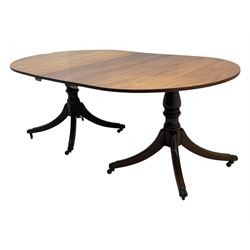 Georgian design mahogany twin pedestal dining table, oval top with reeded edge, single additional leaf, on turned pedestal with four out splayed supports, cast brass hairy paw castors 
