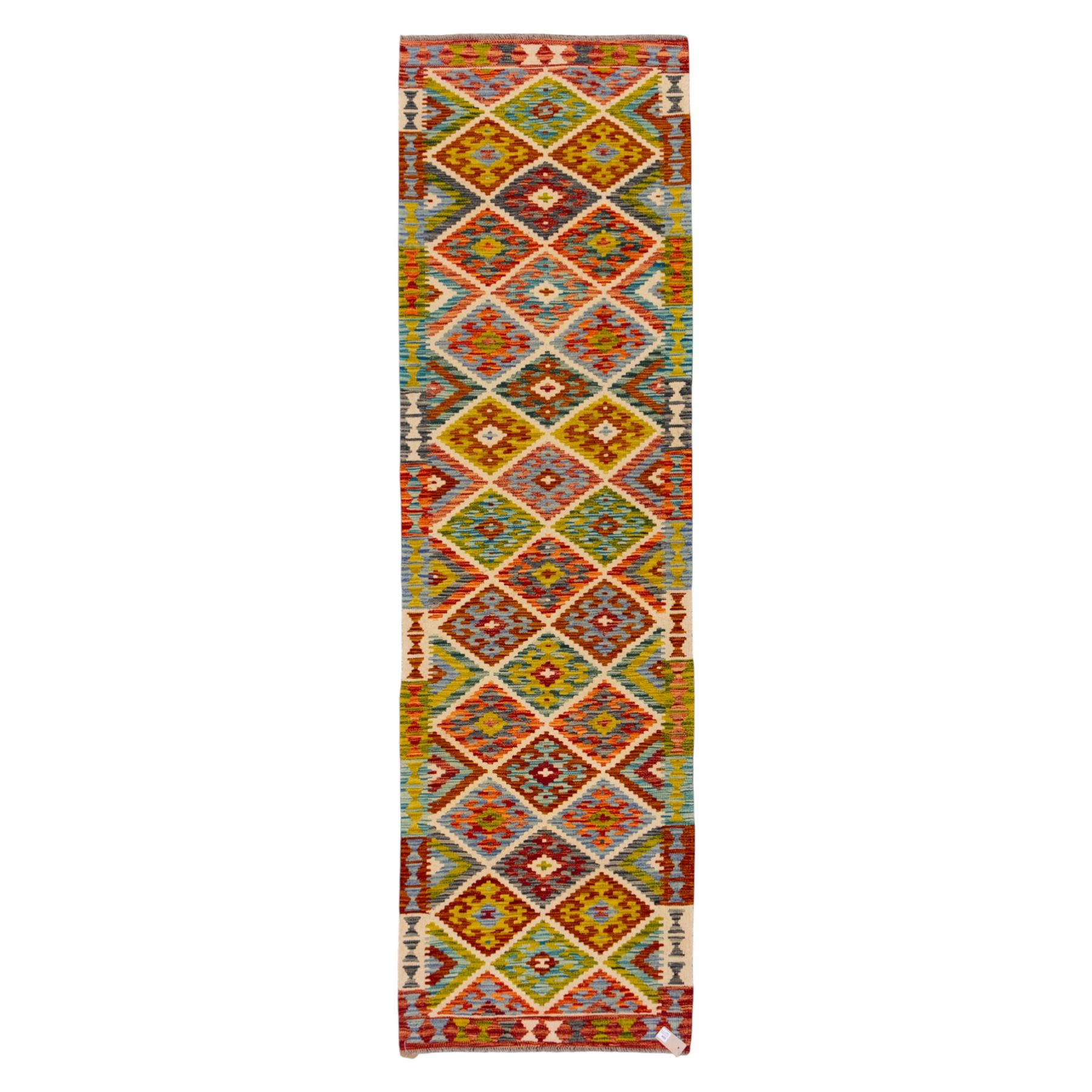 Turkish Anatolian flatweave kilim, ivory field decorated with rows of large stepped lozenge medallions enclosing stylized geometric motifs flanked by narrow geometric side panels, fringe ends 