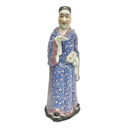  Chinese Republic Period porcelain figure, modelled as scholar holding a book and fan, wearing blue enamelled robes decorated with flower heads, H43cm