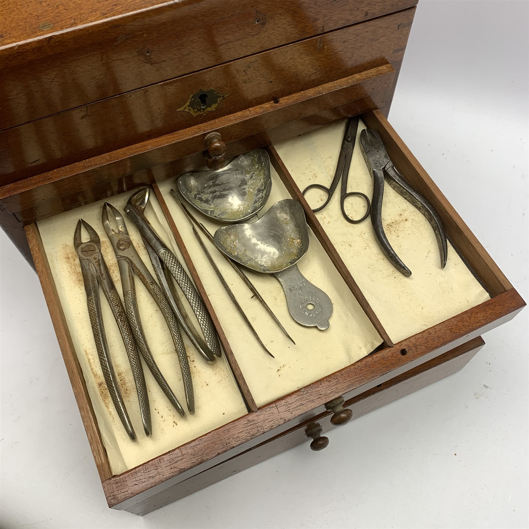  Dentistry - Late Victorian mahogany Dentists cabinet by C. Ash & Co, hinged cover above six long graduated drawers, enclosing a comprehensive arrangement of implements, pharmaceutical bottles, tools, modelling wax, porcelain teeth, 