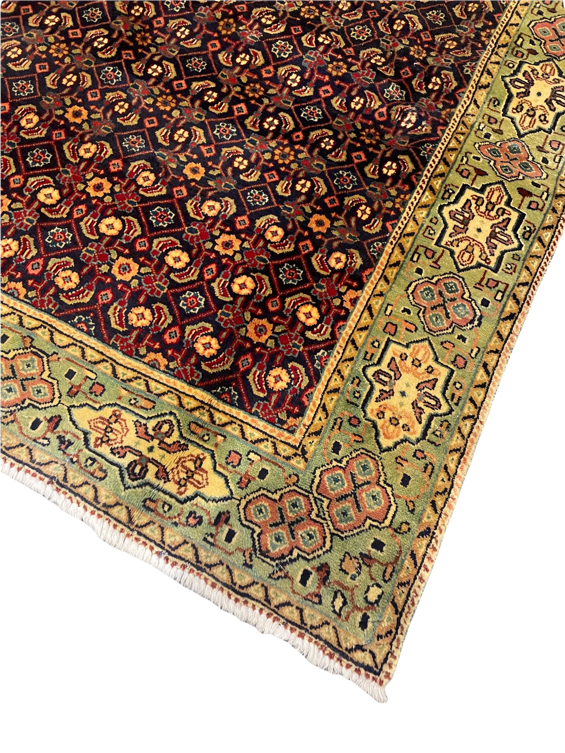 Persian Mahal rug, the blue ground field decorated with repeating Herati motifs, guarded pale ground border decorated with stylised panels