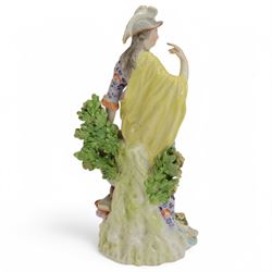 18th century Derby porcelain figure, circa 1775, modelled as Minerva, standing with mask shield, books and owl, against flowering bocage, upon a scroll base encrusted with flowers, H23cm