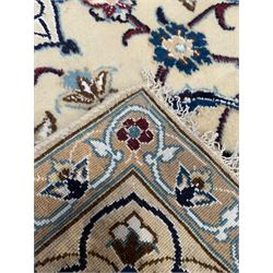 Persian Kashan ivory ground rug, central medallion surrounded by scrolling leafy branches and stylised flowerhead motifs, scrolling border decorated with further stylised plant motifs