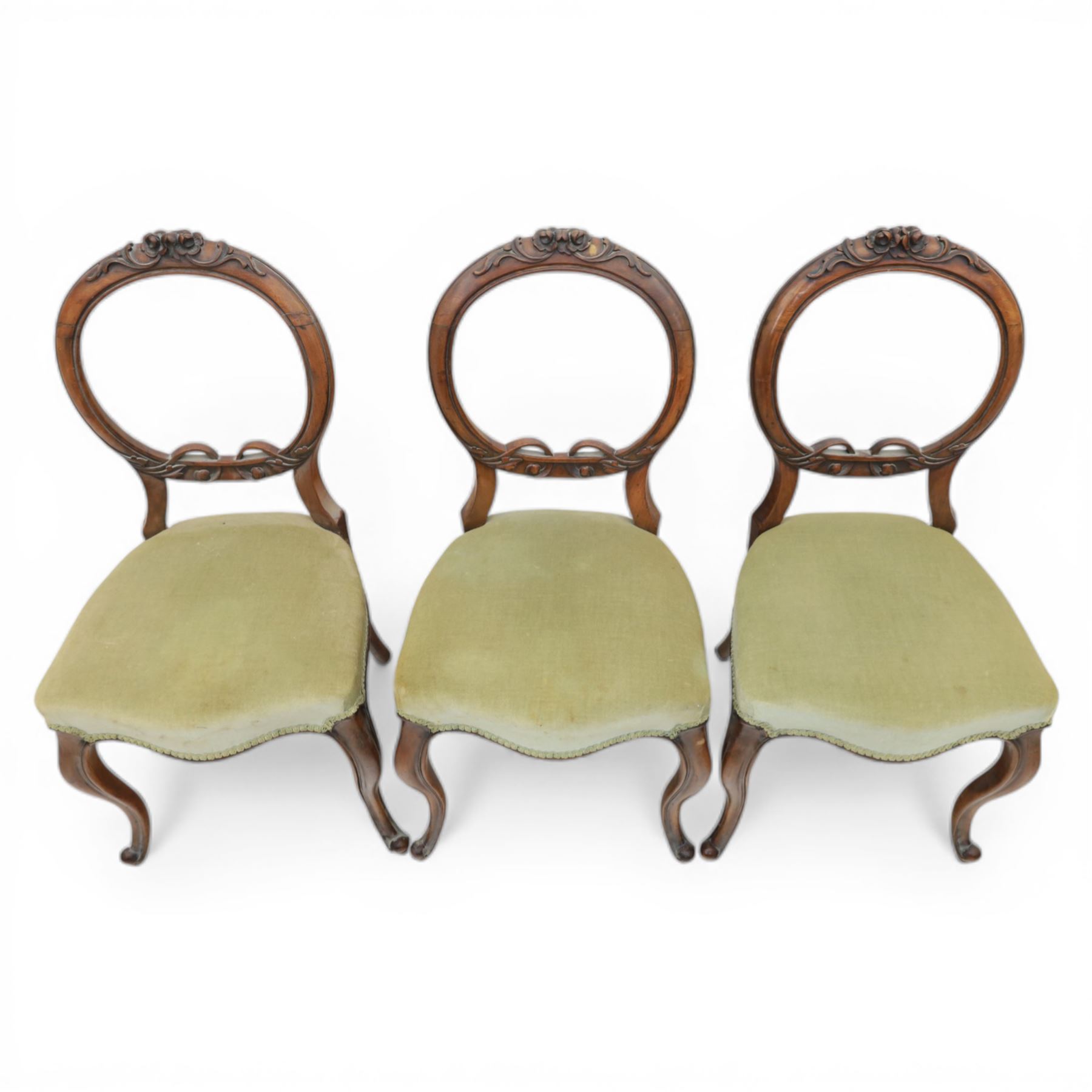 Victorian mahogany dining suite, oval tilt top dining table raised on a quatriform base with paw feet, together with a set of six balloon back dining chairs with green upholstery with cabriole legs 