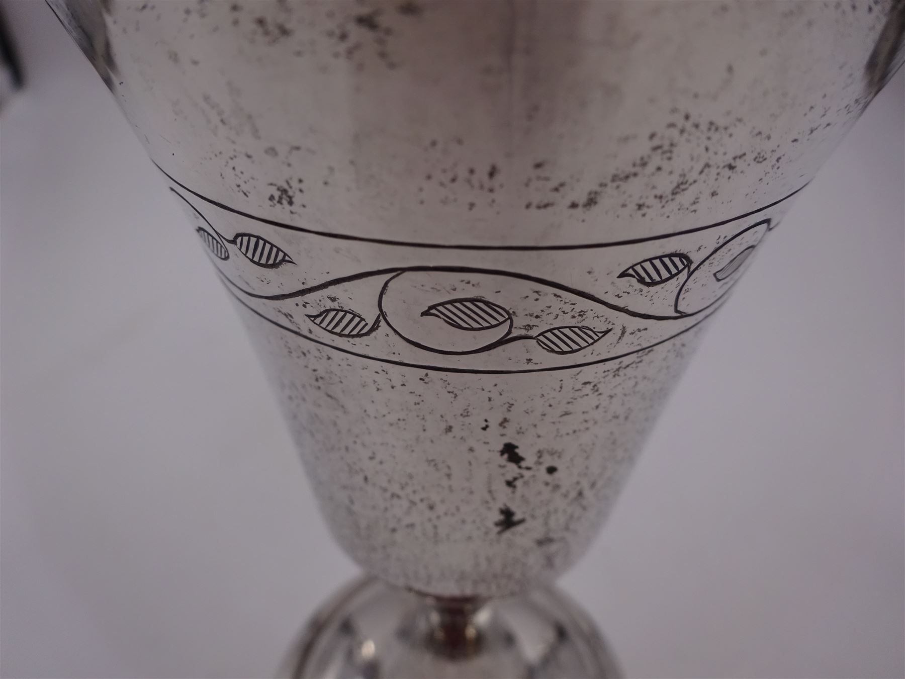 Modern limited edition silver goblet, a replica of the original silver chalice of Lincoln Cathedral, with hand planished decoration, and engraved band of laurel leaves to bowl, with gilt interior, upon waisted stem and circular stepped foot, no. 144/200, hallmarked John Cussell, London 1977, H15cm