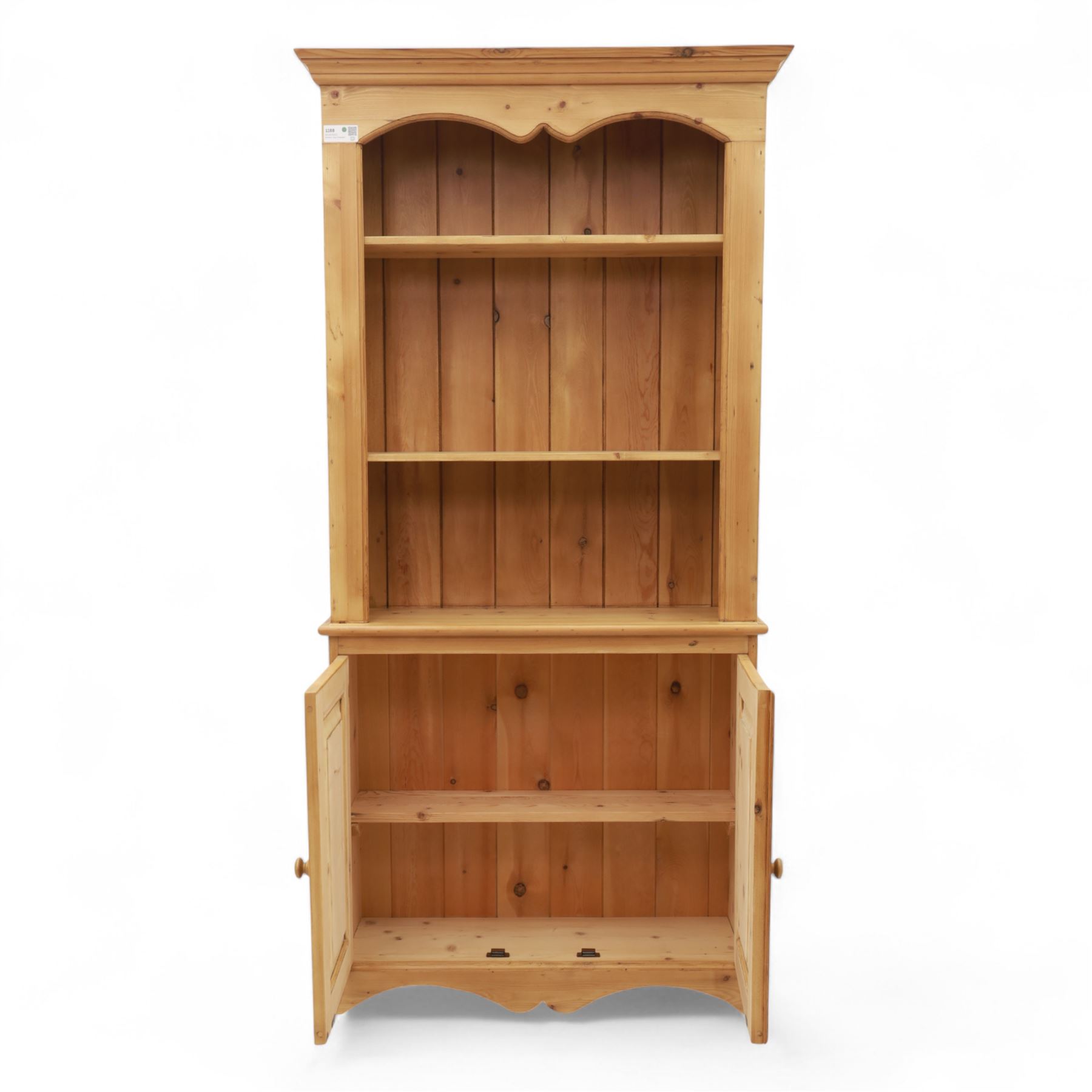 Contemporary pine kitchen dresser, moulded cornice over open plate rack with shaped frieze and two fixed shelves, enclosed lower section with panelled twin doors and shaped plinth base