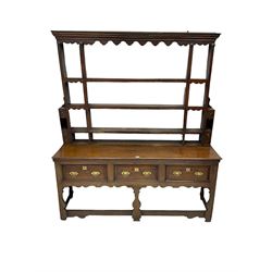 George III oak dresser, projecting cornice over shaped frieze, fitted with three plate racks, the bottom section with rectangular top over three drawers with brass handles, raised on silhouette supports united by stretchers