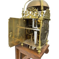 A 20th century replica of a 17th century 30-hour lantern clock with a rope driven verge escapement and countwheel striking, sounding the hours on a bell, with an engraved dial centre, silvered chapter ring and Roman numerals , half hour and quarter hour markers and a pierced and fettled steel hand, with an attached disc engraved “ Clockmaker In Scarborough Ivan Coe, Fecit,”, with engraved side doors, brass finials and dolphin fretwork, on a wooden bracket with pulley.   No weight.
Clocks similar to this were usually individually constructed by engineers working from plans of clocks designed by Claude Reeve, John Wilding, Malcolm Timings and other well-known clockmakers/engineers. 
