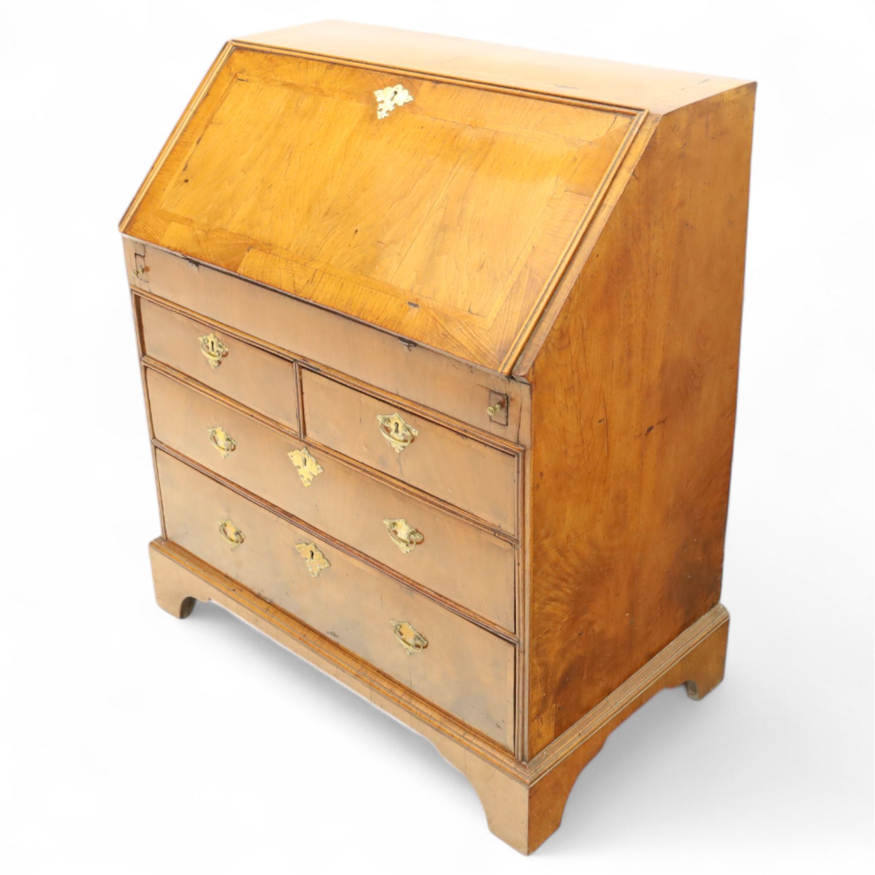 18th century walnut and herringbone banded bureau, the fall front enclosing a stepped and arched interior fitted with pigeonholes, drawers and concealed compartments, green tooled leather writing surface, over two short and three long graduated drawers with brass escutcheons and bail handles, shaped bracket feet