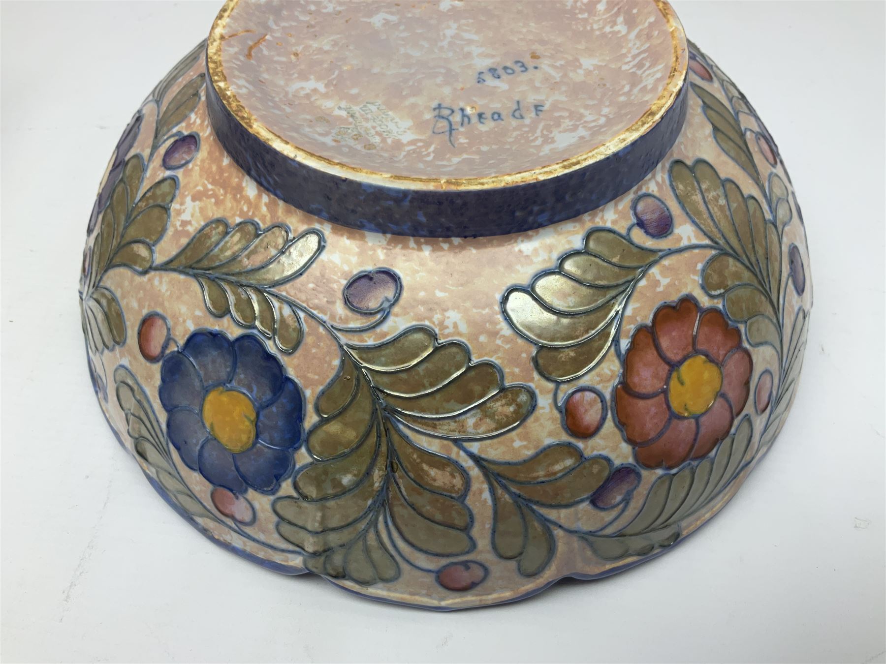 Charlotte Rhead for Crown Ducal ceramics, comprising coffin shaped vase depicting a woman in 1920s dress, a vase with handle, decorated with autumn leaves and a bowl, decorated with flowers and berries, with printed and signed marks beneath, coffin vase H24cm