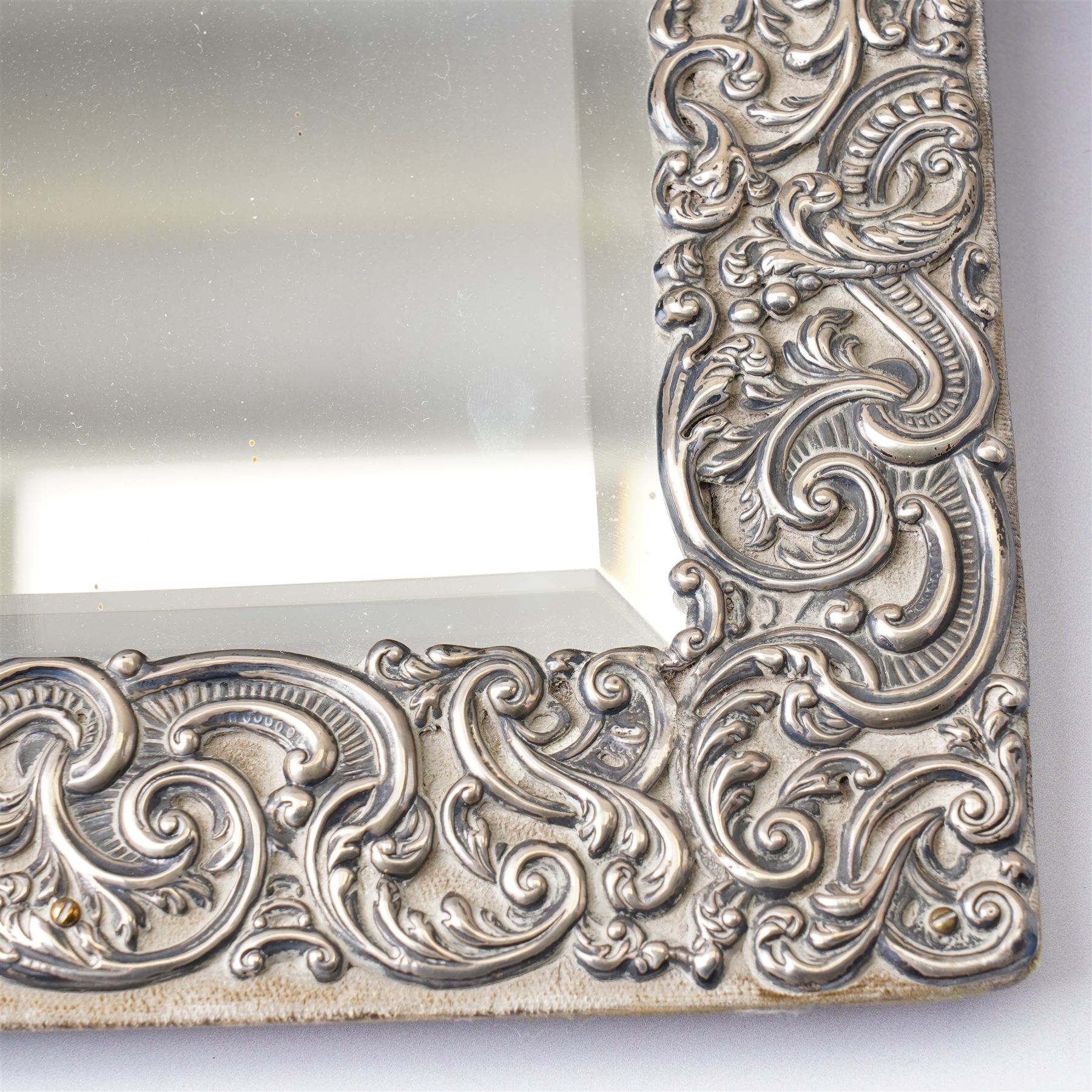 Late Victorian silver mounted dressing table mirror, the frame decorated with scrolls and oval cartouche initialled 'C', bevelled plate on an easel stand 57cm x 38cm London 1899 Maker Charles Henry Dumenil 