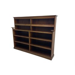 20th century oak double bookcase, ten shelves fitted with hinged spine covers, on moulded plinth base