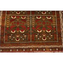 Baluchi hand-knotted prayer rug, dark brown ground divided into six panels decorated with stylised tree-of-life and flowering motifs in madder red and ivory, enclosed by multiple narrow geometric borders, with fringed ends