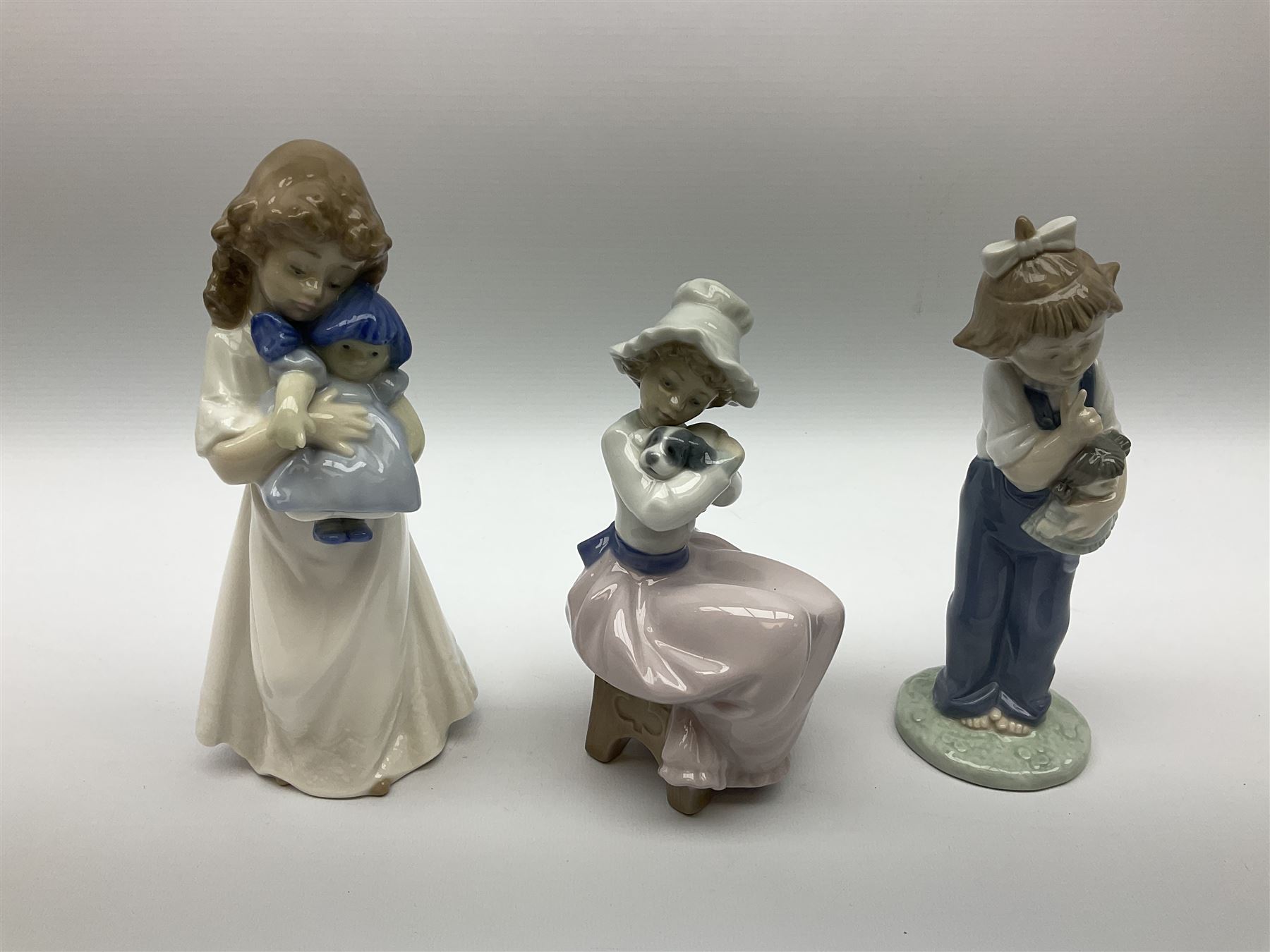 Lladro figure of a girl brushing her hair, together with four Nao