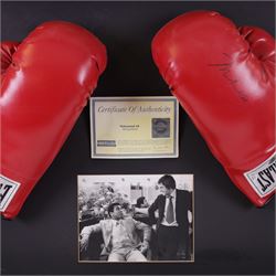 Large framed display containing two Everlast boxing gloves, one signed Mohammed Ali, displayed in frame with black and white photograph of Mohammed Ali speaking with Michael Parkinson, the signed glove has a Steiner authenticity hologram affixed and comes with certificate of authenticity from Steiner Sporting Memorabilia, frame H73cm