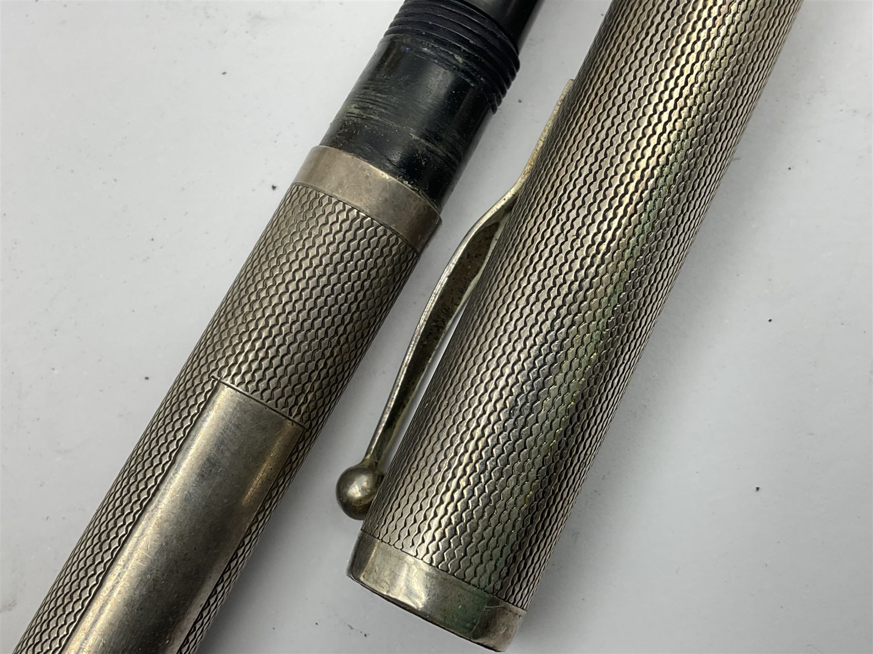 Three parker fountain pens, one example with 14ct gold plated cap and personal engraving, in Parker 51 box, together with a silver Sampson Mordan Everpoint propelling pencil with personal engraving and a silver cased fountain pen with 14ct gold nib and a souvenir bronze Dollfus-Mieg medallion, awarded to John G Sedorski, in fitted case 