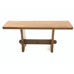 'Acornman' oak bench/occasional table with rectangular adzed top, shaped end supports on sledge feet joined by pegged stretcher carved with acorn signature, by Alan Grainger of Brandsby, York