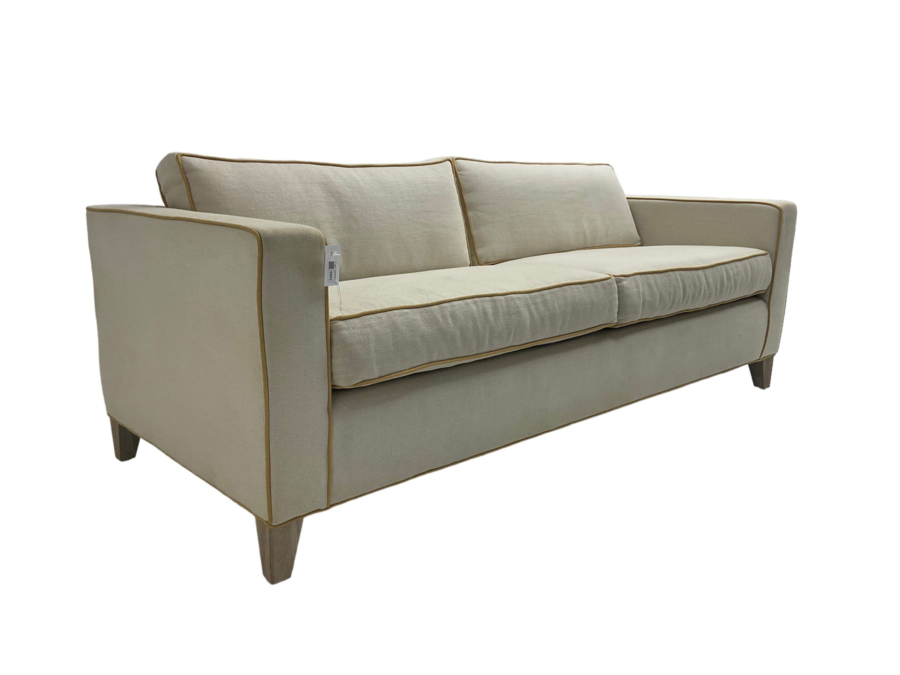 Neptune - pair three seat 'Shoreditch' sofas,  upholstered in cream fabric with yellow stringing