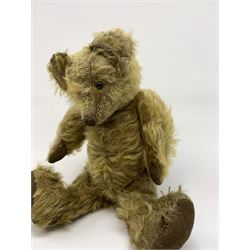Early 20th century English teddy bear, WW1 period, with wood wool filled mohair body, fixed head with one boot button eye and vertically stitched nose and mouth and jointed limbs with cloth paw pads H16