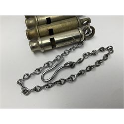 Three Hull City Police 'Metropolitan' whistles by J. Hudson 13 Barr Street Birminham, each with impressed collar number; another 'Metropolitan' police whistle with chain; and an ARP whistle by Hudson & Co with chain (5)