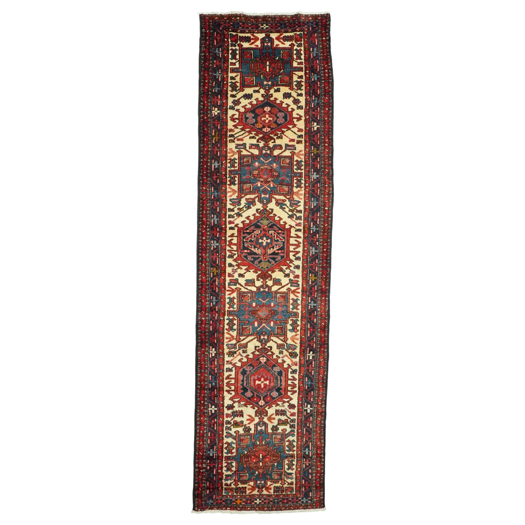 Caucasian Shirvan hand-knotted runner, ivory field decorated with a vertical sequence of bold hexagonal and lozenge medallions, each enclosing stylized geometric motifs, flanked by angular floral latch-hook devices, field dominated by madder red  and ivory with subsidiary colours of indigo, brown, and turquoise, with fringe ends   