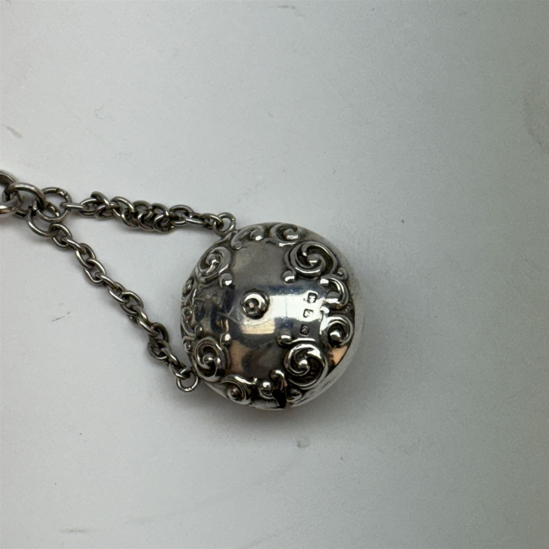 Victorian and later silver chatelaine, the shaped and foliate pierced clasp with embossed oval panel of a courting couple, hallmarked Levi & Salaman, Birmingham 1899, supporting six accessories on five chains: a circular mirror embossed with putti, hallmarked Henry Matthews, Birmingham 1911, pencil holder engraved with foliate scrolls, hallmarked Francis Webb, Birmingham 1914, conical scent bottle decorated with bamboo, (unmarked but testing as silver), aide memoire embossed with putti, hallmarked Samuel M Levi, Birmingham 1911, tape measure of compressed spherical form, hallmarked Henry Matthews, Birmingham 1899, and a purse with embossed putti, hallmarked Birmingham 1909, makers mark worn and indistinct, at longest point L31cm

